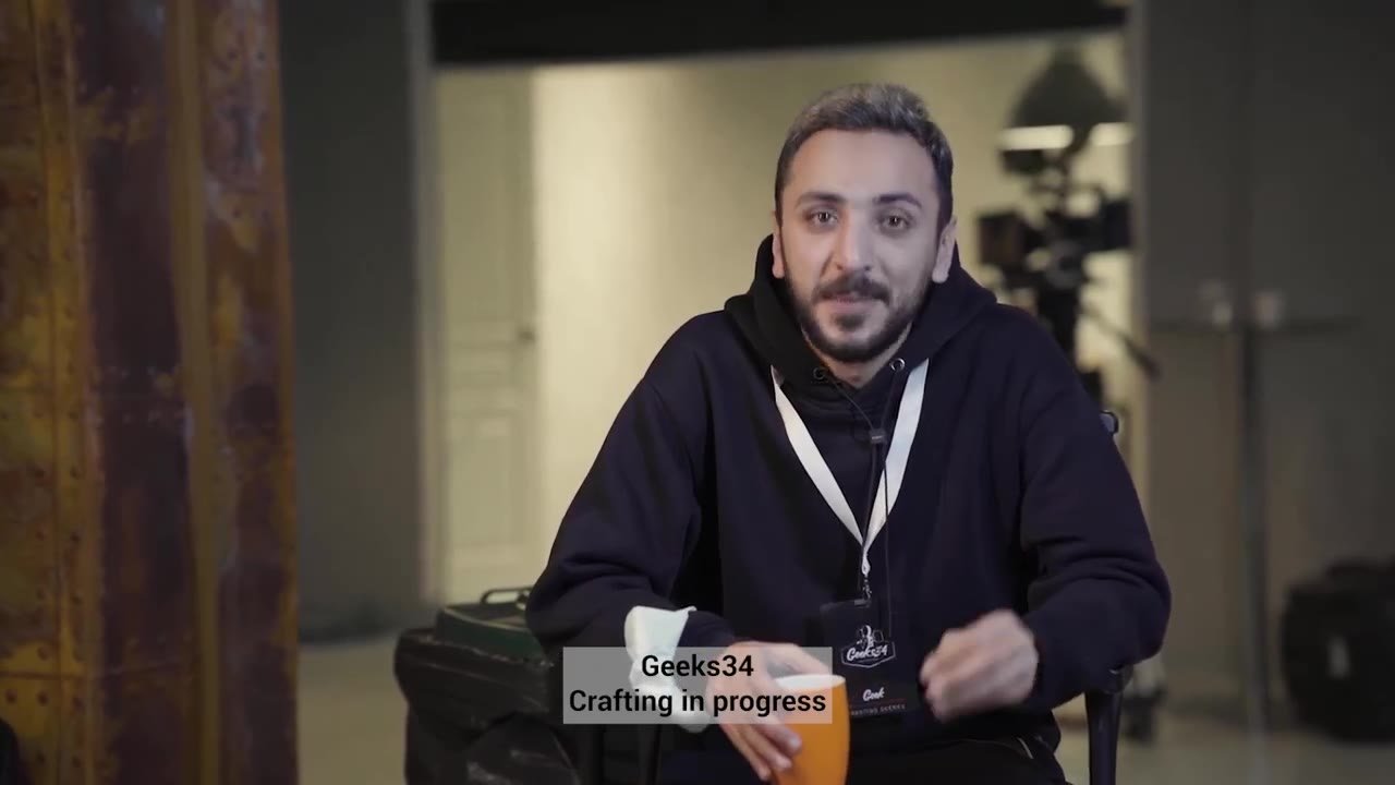 أحمد في 2022 مع فنجان قهوة، وتحته Geeks34 Crafting in progress